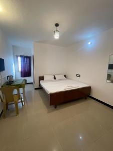 a bedroom with a bed and a table in it at Radiant Hill Homestay in Kodaikānāl