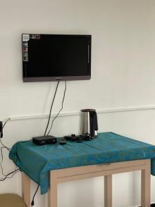 a flat screen tv on a wall with a table at Radiant Hill Homestay in Kodaikānāl