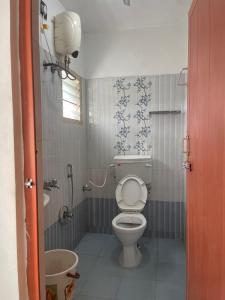 a bathroom with a toilet and a sink at Radiant Hill Homestay in Kodaikānāl