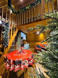 a dining room with a table and a christmas tree at Mountain Shadow Cottage in Racha in Ghebi