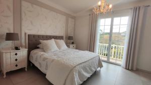 Una habitación blanca con una cama y una ventana en Cosy Orchidée - Villa Élégance, Piscine & Pyrénées "5 étoiles", en Baigts-de-Béarn 9 fotos más