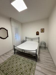 ein Schlafzimmer mit einem Bett und einem Teppich in der Unterkunft Elena's apartment - casa gialla in Quartesana