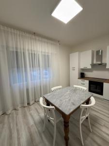ein Esszimmer mit einem Tisch und weißen Stühlen in der Unterkunft Elena's apartment - casa gialla in Quartesana