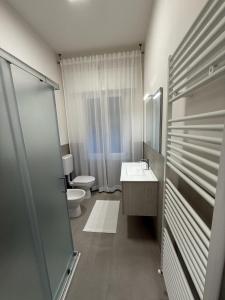 a white bathroom with a toilet and a sink at Elena's apartment - casa gialla in Quartesana