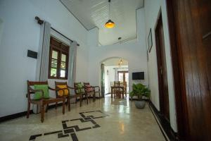 Una sala de estar con sillas y un comedor. en Sleeperwood Villa, en Unawatuna