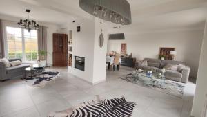 una sala de estar con una alfombra de cebra en el suelo en Cosy Orchidée - Villa Élégance, Piscine & Pyrénées "5 étoiles", en Baigts-de-Béarn