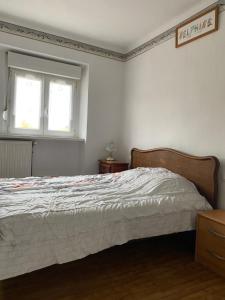 a bedroom with a white bed and a window at La Maison des Pierres in Zinswiller