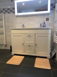 a bathroom with a sink and a mirror and two mats at La Maison des Pierres in Zinswiller