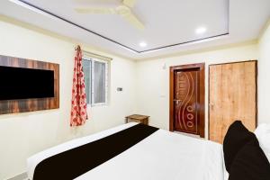 a bedroom with a bed and a flat screen tv at Hotel O R Square NARSINGI in Gundipet