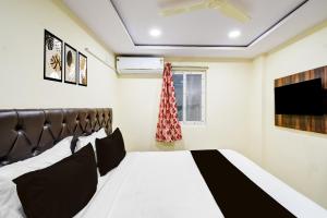 a bedroom with a black and white bed and a window at Hotel O R Square NARSINGI in Gundipet +23 photos
