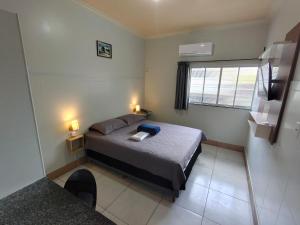 a small bedroom with a bed and a window at Hotel Val-de-Cans Aeroporto in Belém