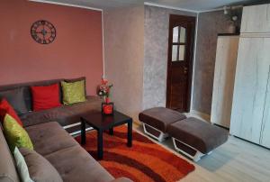 sala de estar con sofá y 2 reposapiés en Casa Crissio, en Sinaia