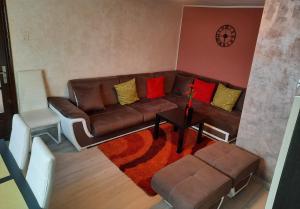 una sala de estar con un sofá marrón con almohadas coloridas en Casa Crissio, en Sinaia