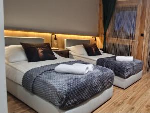una camera da letto con due letti con asciugamani sopra di Sądelska Chałpa a Murzasichle