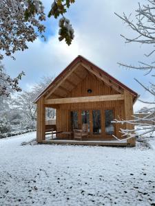 a log cabin with snow on the ground at Chalet Chalus in Châlus