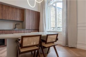 eine Küche mit Tisch und Stühlen und einem Fenster in der Unterkunft Suite Velours by Collection Aura - Maison les Arcades face à la gare de Charleville-Mézières in Charleville-Mézières