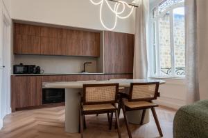 eine Küche mit Tisch und Stühlen und einem Fenster in der Unterkunft Suite Velours by Collection Aura - Maison les Arcades face à la gare de Charleville-Mézières in Charleville-Mézières + 28 Fotos