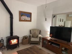 sala de estar con TV y chimenea en Apartamento Martín, en Ardales