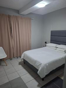 Grace Villas 3 في شرق لندن: غرفة نوم بها سرير أبيض كبير في الغرفة