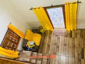 un soggiorno con tende gialle e divano di Chale Manticas aconchego na Serra da Mantiqueira a Costas