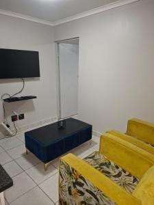 Grace Villas 3 في شرق لندن: غرفة معيشة بها أريكة وطاولة