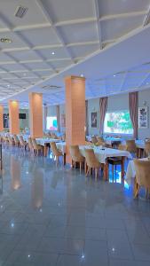 a dining room with tables and chairs in a building at Tanger Med Hotel, Conference & Catering in Ghdar Defla