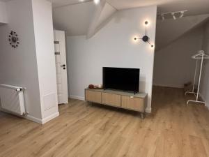 Suwałki Kościuszki Centrum في سووالكي: غرفة معيشة مع تلفزيون بشاشة مسطحة على طاولة