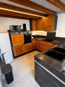 ラ・モットにあるT2 moderne rdc toutes commoditésの大きなキッチン(木製キャビネット、シンク付)