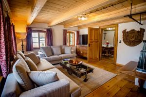 een woonkamer met een bank en een tafel bij Historisches Baderhaus mit eigenem Saunauhaus in Roding