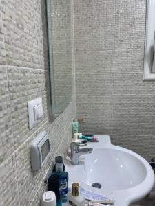 a bathroom with a white sink and a mirror at Madinaty golden stay in Madinaty