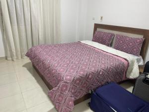 a bedroom with a bed with a purple comforter at Madinaty golden stay in Madinaty
