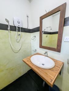 a bathroom with a sink and a mirror at Femingo by Costels in Hiriketiya