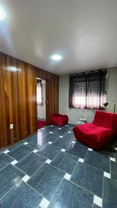 un soggiorno con divano rosso e pavimento piastrellato di Red Office Morada Del Sol 103 a Rio Grande