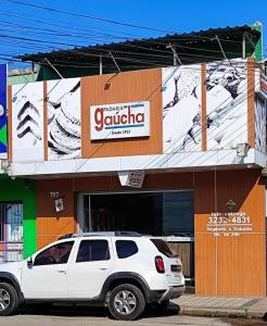 un SUV bianco parcheggiato di fronte a un edificio di Red Office Morada Del Sol 103 a Rio Grande