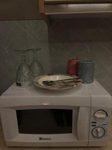 a white microwave with a plate on top of it at The little nest in Islamabad