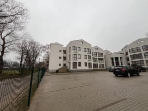 a car parked in a parking lot in front of buildings at Tėčio ir Dukters pajūrio apartamentai - Šventojoje in Palanga +6 photos