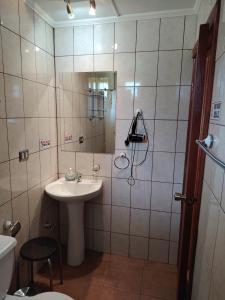 un bagno con lavandino e doccia con specchio di ECOHOSTAL HUELLAS DEL BOSQUE a Valdivia Altre 30 foto