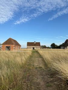 una vecchia casa in un campo di erba alta di Grange transformée a Crucheray
