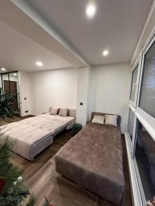 a bedroom with two beds and a couch at Tėčio ir Dukters pajūrio apartamentai - Šventojoje in Palanga