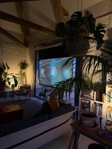 un soggiorno con divano e TV a grande schermo di Grange transformée a Crucheray