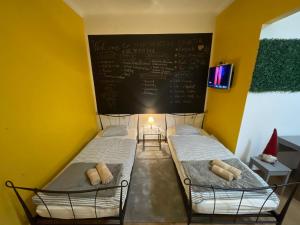 two beds in a room with a chalkboard on the wall at Downtown-Room Zagreb in Zagreb
