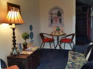 a living room with a table and chairs and a lamp at 1 Murray House in Newport