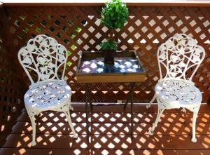 two white chairs and a table with a potted plant at 1 Murray House in Newport