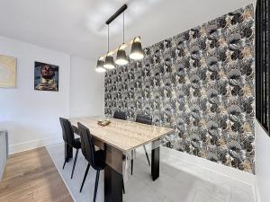 克莱蒙费朗Appartement spacieux Montferrand的一间有桌子和黑色椅子的餐厅 更多5张照片