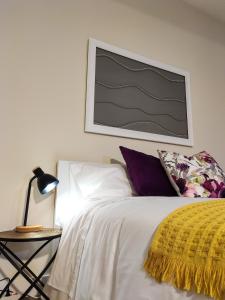 a bedroom with a white bed with a yellow blanket at Vitoria's Vale in Funchal