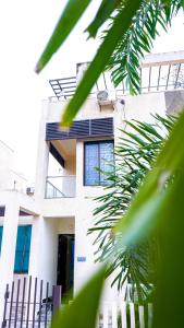 una casa blanca con una valla delante en The Sea Garden, en Mahabalipuram