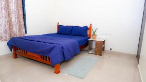 Un dormitorio con una cama con sábanas azules y una mesa. en The Sea Garden, en Mahabalipuram