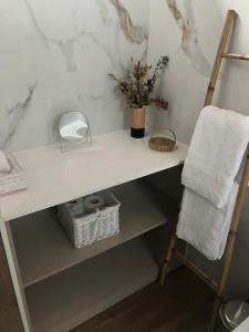 a white counter with a vase of flowers and a towel at Casas do Abô Fredo in Sendim +27 photos