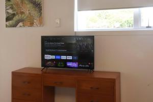 Un televizor și/sau centru de divertisment la Cathedral Cove Cottage