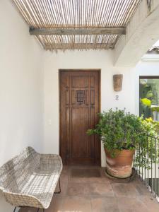a porch with a wooden door and a potted plant at Casapueblo Rent Cachagua CP 02 in Cachagua